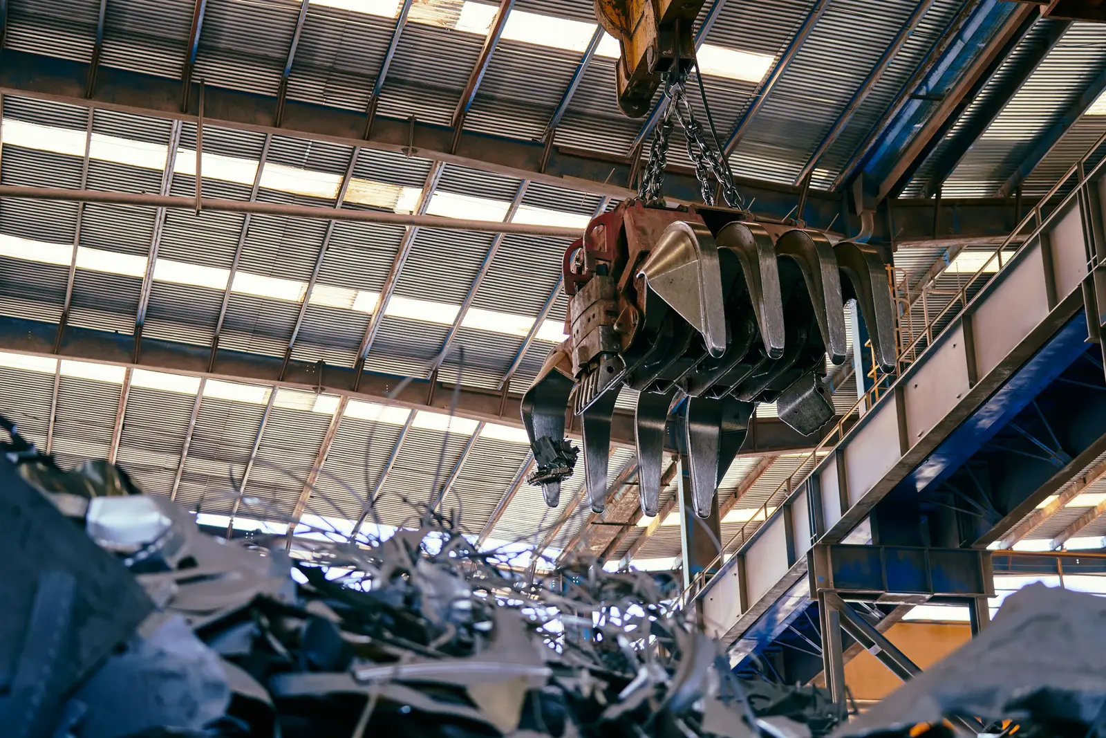 Overhead magnet lifting scrap in a processing hall